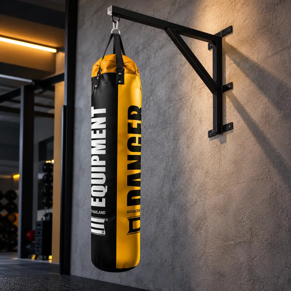 Suporte de parede para saco de boxe com saco de treino preto e amarelo numa sala de treino